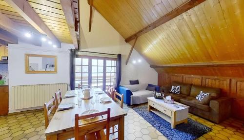 a living room with a table and a couch at Casa-Le Gerland : joli duplex dans chalet St-Véran in Saint-Véran
