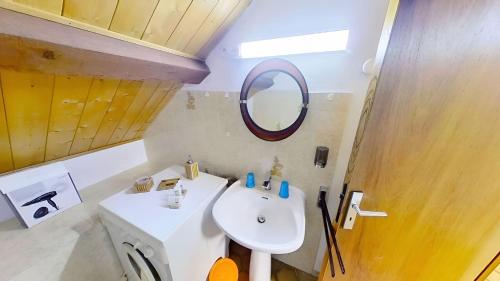a bathroom with a white sink and a mirror at Casa-Le Gerland : joli duplex dans chalet St-Véran in Saint-Véran