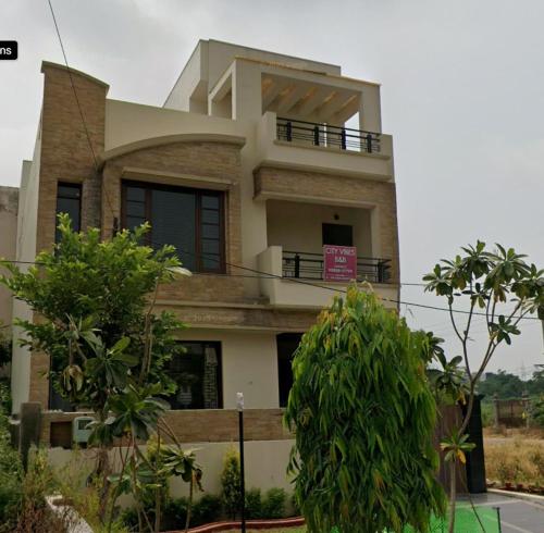 Una casa grande con un balcón en la parte superior. en City Vibes B&B, en Amritsar
