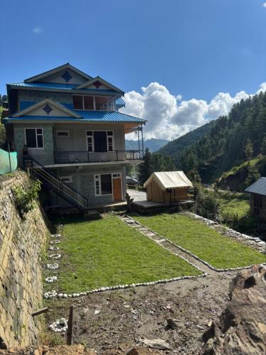 a house on top of a hill with a yard at River Era by Naavagat in Jibhi
