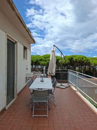 a patio with a table and umbrella on a balcony at La Casetta Bianca in Follonica