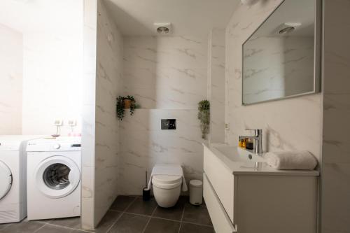 a white bathroom with a washing machine and a sink at O&O Group - 3BR Skyline Retreat on the 24th Floor in Bat Yam