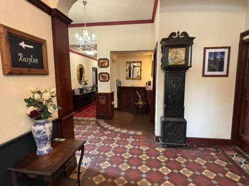 a hallway with a grandfather clock in a room at Royal Goat Hotel in Beddgelert