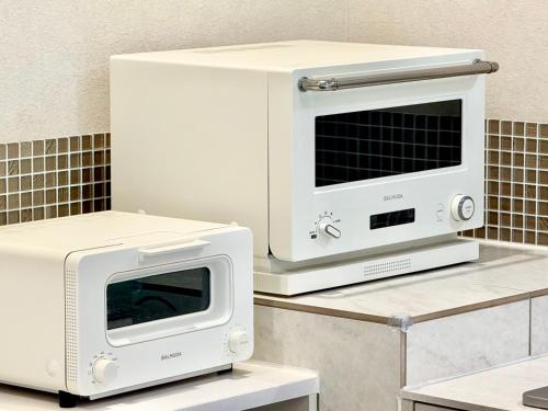 a microwave and a toaster oven on a table at 遊び場いっぱい Kidsʻ Play Villa 庭付き貸別荘 最大14名 屋根付きBBQ in Kimitsu
