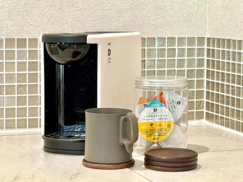 a coffee maker and a cup on a counter at 遊び場いっぱい Kidsʻ Play Villa 庭付き貸別荘 最大14名 屋根付きBBQ in Kimitsu