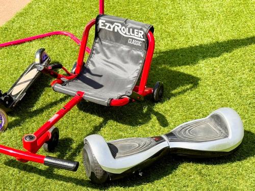 a toy stroller and a golf cart on the grass at 遊び場いっぱい Kidsʻ Play Villa 庭付き貸別荘 最大14名 屋根付きBBQ in Kimitsu