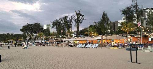 a beach with chairs and umbrellas on the sand at Sri sayang pearl view in Batu Ferringhi