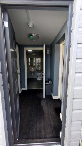 a hallway of a bathroom with a sink and a toilet at OYO Shore Surf Lodge in Newquay