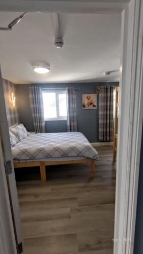 a bedroom with a bed and a window at OYO Shore Surf Lodge in Newquay