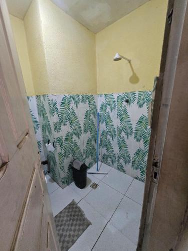 a bathroom with a shower with green leaves on the wall at Aluguel de quarto por diaria proximo ao aeroporto e rodoviaria in São Luís