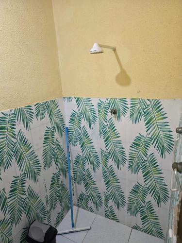 a bathroom with a green palm tree mural on the wall at Aluguel de quarto por diaria proximo ao aeroporto e rodoviaria in São Luís