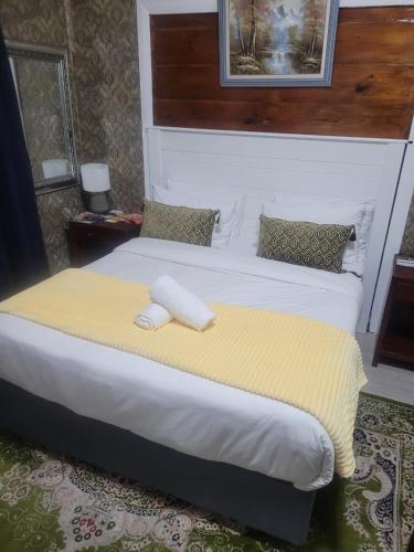 a bedroom with a large bed with a yellow blanket at Prime Executive Accommodation in Cape Town