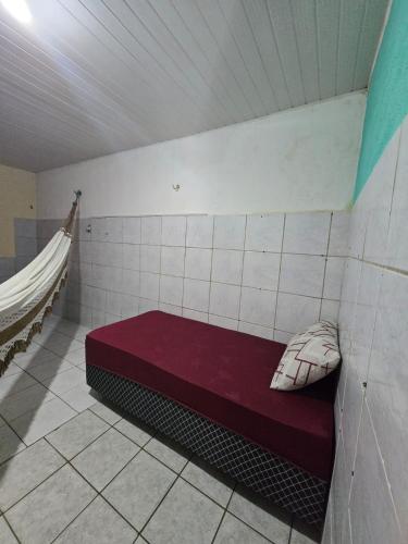 a small room with a red bed in a wall at Aluguel de quarto por diaria proximo ao aeroporto e rodoviaria in São Luís
