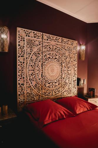 a bedroom with a red bed with a large headboard at Ô Secret in Liège
