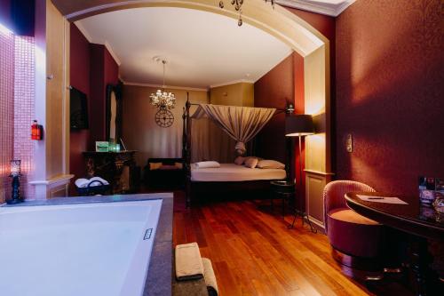a room with a bedroom with a bed and a tub at Ô Secret in Liège