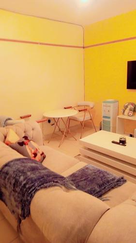 a room with a bed and a table in it at Bustani Homes apartment in Kahawa