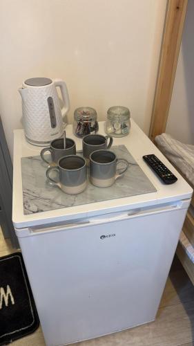 a stove top with four pots and pans on it at OYO Shore Surf Lodge in Newquay