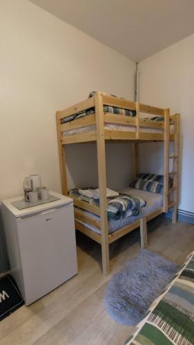 two bunk beds in a room with a refrigerator at OYO Shore Surf Lodge in Newquay