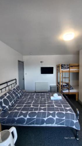 a bedroom with a bed and a flat screen tv at OYO Shore Surf Lodge in Newquay