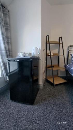 a black shelf in a room with a ladder at OYO Shore Surf Lodge in Newquay