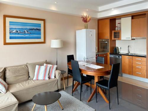 a living room and kitchen with a table and a couch at Boca do Rio Arade in Estômbar