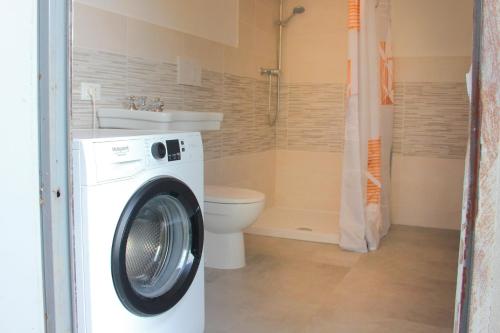 una lavadora en un baño con inodoro en Relax Merigge - Piscina a Comune - Parcheggio, en Pieve a Maiano