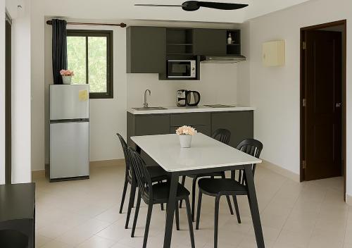 a kitchen with a table and chairs and a refrigerator at Beverly Hills Villa Patong in Patong Beach