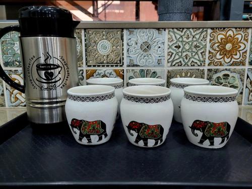 a group of cups with cows on them on a counter at Atulya Krishna Vilas 4Room villa, 10min prem mandir in Mathura