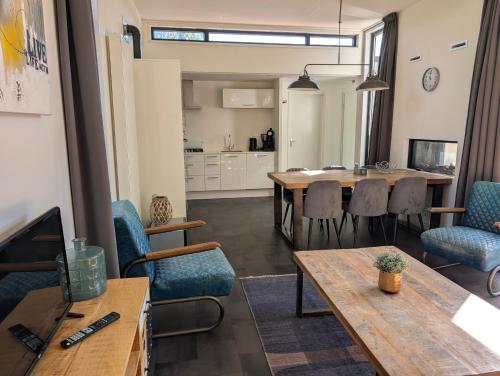 a room with a table and chairs and a kitchen at Holiday home - area AMSTERDAM - 6 people in Halfweg