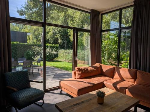 a living room with a couch and a large window at Holiday home - area AMSTERDAM - 6 people in Halfweg