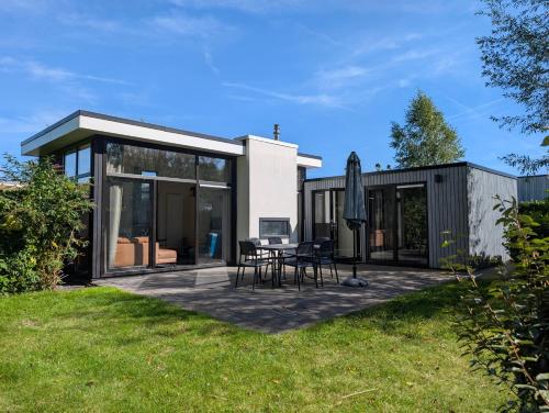 a glass house with a table and chairs on a patio at Holiday home - area AMSTERDAM - 6 people in Halfweg