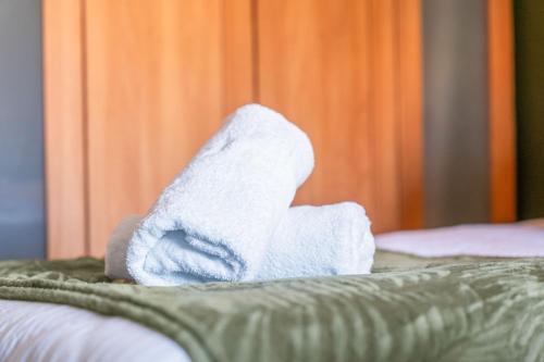 a pile of white towels sitting on top of a bed at Bham Central - free parking in Birmingham