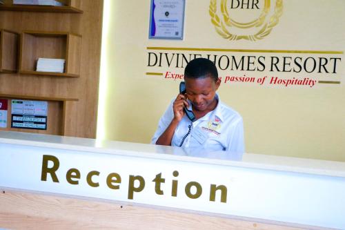 a man talking on a cell phone at a reception at Divine Homes Resort Kisumu in Kisumu