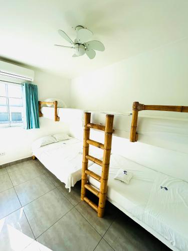 a bedroom with two bunk beds and a ladder at Las palmeras de bocapan in Tumbes
