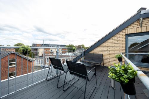 a balcony with two chairs and a bench on a building at Withington Apartments in Manchester