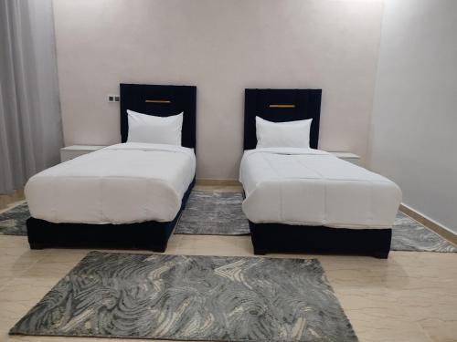two beds sitting next to each other in a room at 2 Voies Résidence in Dakhla