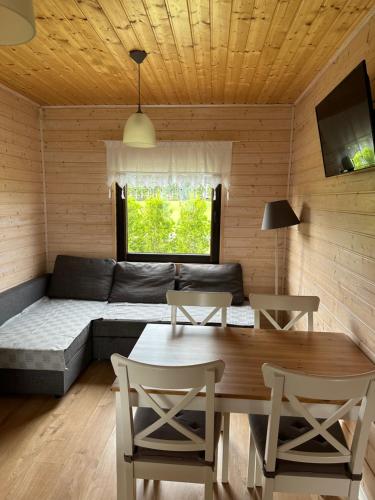 a living room with a couch and a table at Domki Letniskowe Ratownik in Sarbinowo