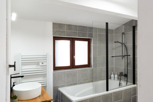 a bathroom with a white tub and a shower at L'impasse - Maison avec jardin proche du centre in Rouen