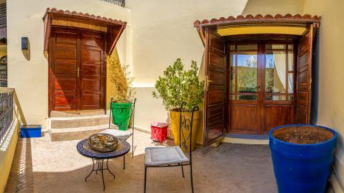 a room with a door and a table and chairs at Riad Dar Pierre in Fès