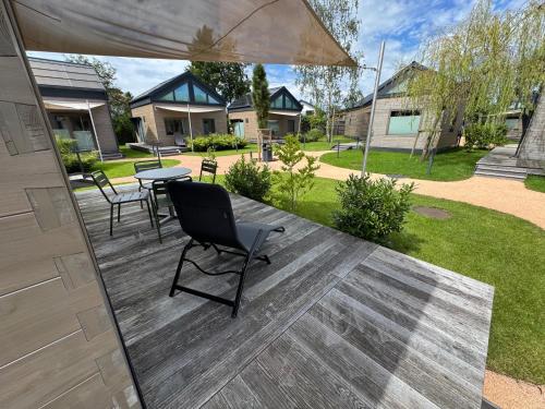 a patio with a table and chairs and an umbrella at Tiny Häuser am Mattsee in Mattsee