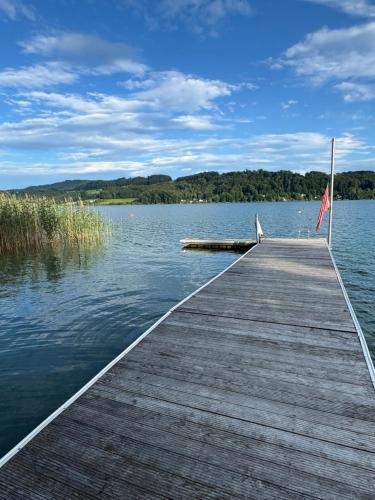 a dock on a lake with a flag on it at Tiny Häuser am Mattsee in Mattsee