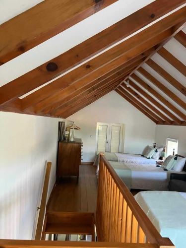 a attic bedroom with two beds and a staircase at Casa Herbarium in Prazeres