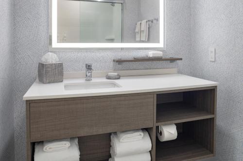 a bathroom with a sink and a mirror and towels at Home2 Suites By Hilton Kittery in Kittery