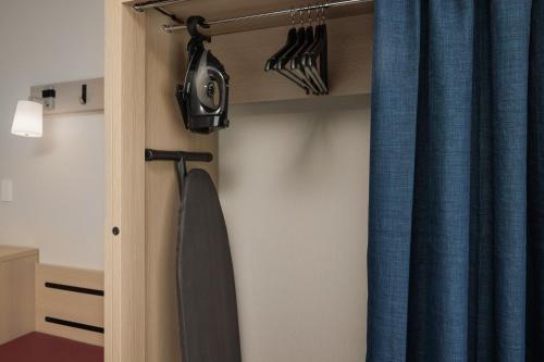 a room with a bedroom with blue curtains at Home2 Suites By Hilton Kittery in Kittery