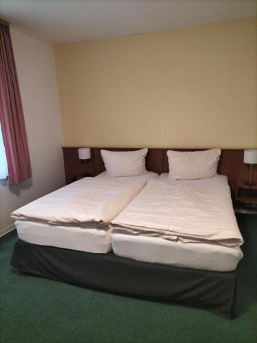 a bedroom with two beds with white sheets and pillows at Hotel und Restaurant am Bismarckturm in Erfurt