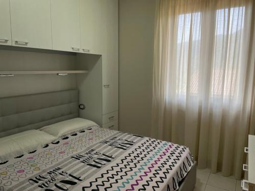 a bedroom with a bed and a large window at Maison della Presolana in Songavazzo