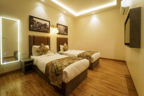 a hotel room with two beds and a television at Sugar Stars Inn in Varanasi