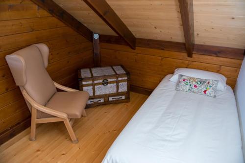 a bedroom with a bed and a chair in a attic at Acogedora Casa de Madera con piscina in Güimar