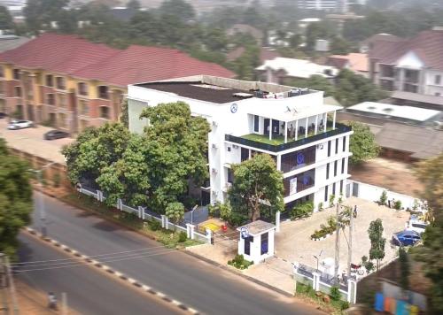 a large white building with a green roof on a street at Uranium Continental Hotel - UCH in Kaduna