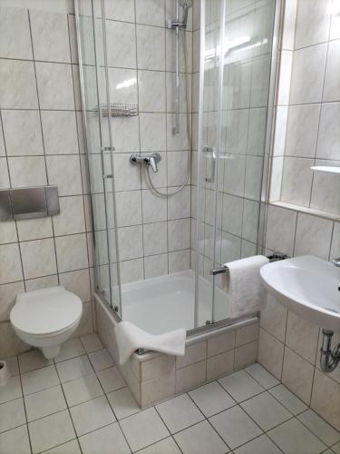 a bathroom with a shower and a toilet and a sink at Hotel und Restaurant am Bismarckturm in Erfurt